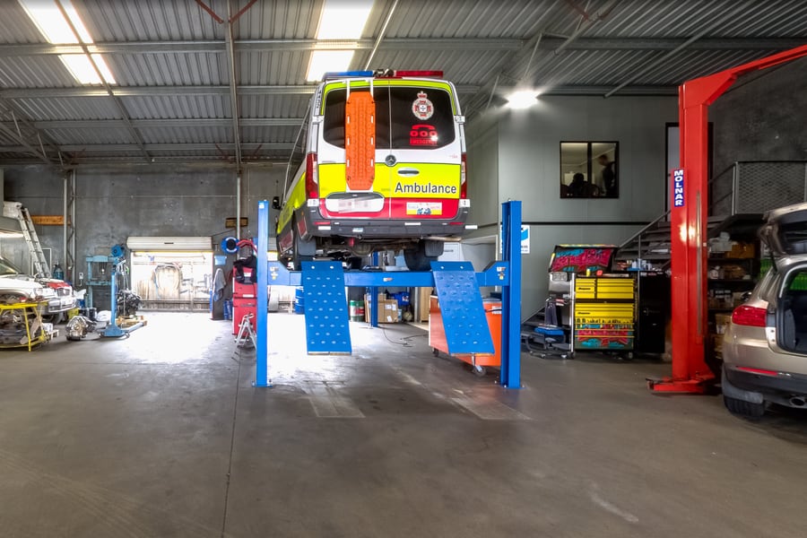 A Queensland Ambulance Service van up on the four-post hoist inside the Ken Day's Automotive Services workshop